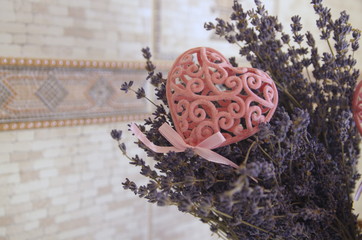 On the table is a basket of dried purple lavender and decorative pink openwork hearts.