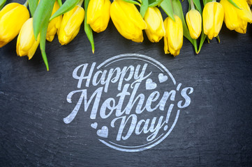 Happy Mother's Day! Flat lay yellow tulips on black background
