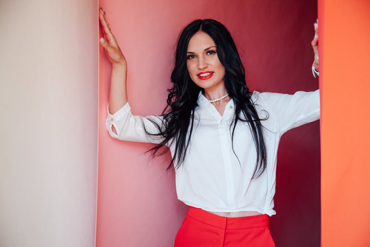 Portrait Of A Business Woman Brunette In A Red Business Suit In The Office