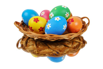 Colorful painted Easter eggs in the basket reflecting on the white background