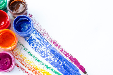 cans of colored paint gouache with colored stripes and brushes