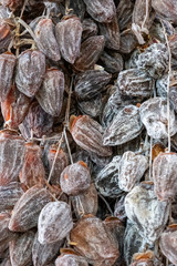 Dried persimmon berries. Large, ripened vegetables. Selling a crop in the market. Natural, healthy, vitamin-rich foods. Food for health.