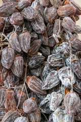 Dried persimmon berries. Large, ripened vegetables. Selling a crop in the market. Natural, healthy, vitamin-rich foods. Food for health.