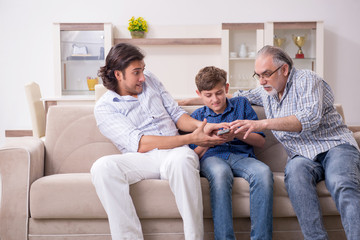 Boy and his father and his grandfother indoor