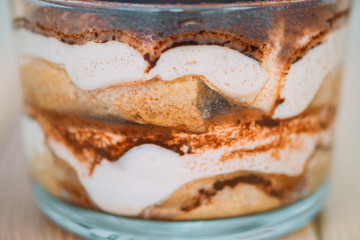 Italian dessert tiramisu  in a transparent glass closeup.