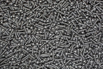A lot of tapping metal or iron screws, screws as a background, wallpaper or texture, industrial background and concept