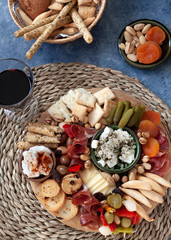 Cheese board with appetizer selection, cheese variety, cured meat, crackers, olives. Colorful meal. Top view.