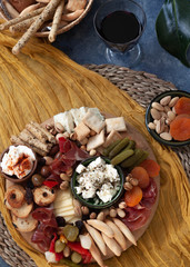 Cheese board with appetizer selection, cheese variety, cured meat, crackers, olives. Colorful meal. Top view.