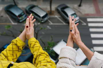 hands of cos girls in pyjamas, clapping from their balcony to support those fighting the coronavirus