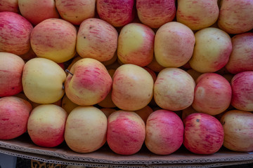 Multi-colored apples in a box. Selling crops on the market. Natural, healthy, vitamin-rich foods. Food for health. A variety of types of apples: yellow, red, green, variegated, with dots.