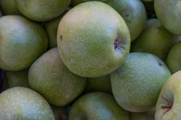 Multi-colored apples in a box. Selling crops on the market. Natural, healthy, vitamin-rich foods. Food for health. A variety of types of apples: yellow, red, green, variegated, with dots.