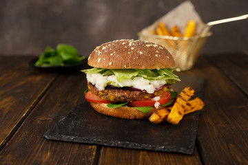 Delicious fresh home-made vegan lentils burger on a rustic dark background