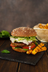 Vertical shot of home-made vegan lentils burger on a rustic dark background