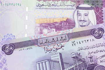 A purple fifty dinar note from Iraq close up with a five riyal note from Saudi Arabia