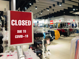 Obraz premium Closed due to covid-19 sign of coronavirus. Information warning text about quarantine in a mall store.