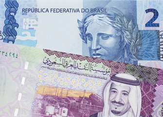 A five Saudi riyal bank note with a blue two Brazilian reais bill.  Shot in macro.