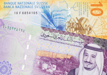 A yellow, ten Swiss franc note with a five Saudi riyal bank note from Saudi Arabia's central bank