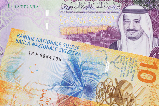 A Yellow, Ten Swiss Franc Note With A Five Saudi Riyal Bank Note From Saudi Arabia's Central Bank