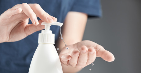Female hands using hand sanitizer gel pump dispenser. The concept of hand disinfection. - obrazy, fototapety, plakaty