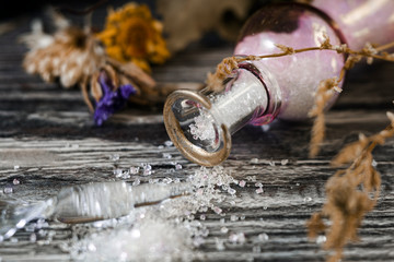 Set for witches. An overturned vial of magic powder and dried herbs.