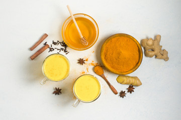 Obraz na płótnie Canvas ingredients for Indian traditional Golden milk with turmeric, ginger, spices, honey. healing effect of the drink. antiviral therapeutic antioxidant.