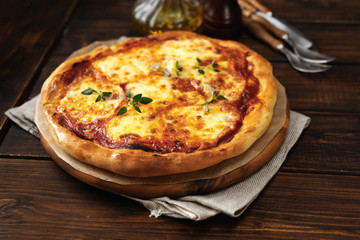 Fresh and appetizing pizza Margherita on dark wooden background