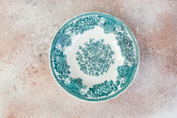 Antique porcelain dish on concrete background.