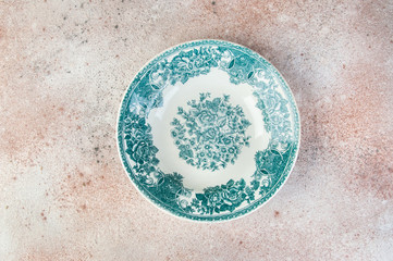 Antique porcelain dish on concrete background.