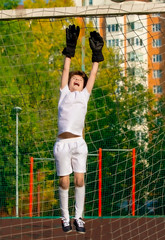 Summer soccer tournament for young kids. football club. emotions and joy of the game. Young goalie. Kids - soccer champion. Boy goalkeeper in football sportswear on stadium with ball. Sport concept.