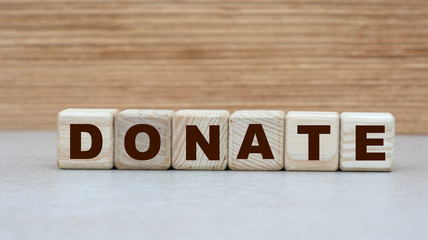 concept of the word DONATE on cubes on a wooden background