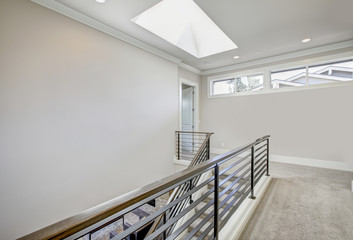 Second floor landing features skylight over the staircase. Luxury American modern home.