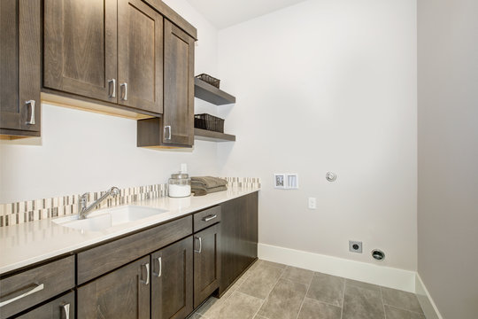 Beautiful Laundry Room With Dark Brown Cabinets. Luxury American Modern Home.