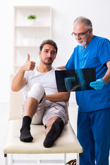 Obraz premium Leg injured man visiting old doctor in first aid concept