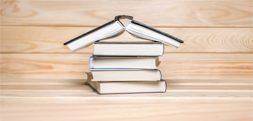 Quarantine background. Stay at home concept. House made with books piled on wooden background Read books background. COVID-19 impact. Basic rule of coronavirus quarantine. Book Forum. Banner