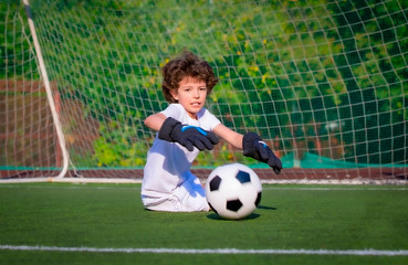 Summer soccer tournament for young kids. football club. emotions and joy of the game. Young goalie. Kids - soccer champion. Boy goalkeeper in football sportswear on stadium with ball. Sport concept.