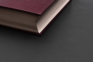 Maroon book on a black background. Copy space. Empty cover