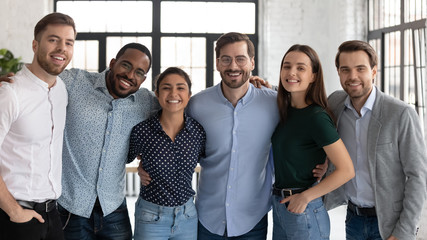 Group portrait of smiling diverse multiracial businesspeople look at camera posing in office...