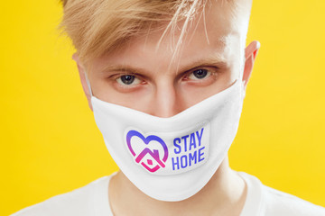Portrait of a man in a protective face mask with the inscription "Stay home".