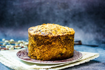 Tasty easter cake with almond flakes on a dark background, next to a pussy-willow twig. The concept of Easter baking for the holiday, copy space