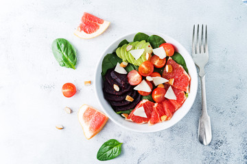 Red grapefruit beet spinach tomato salad in a bowl