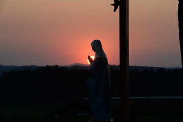 Sonnenuntergang vor Marienstatue und Kreuz