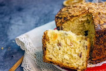 Panettone delicious christmas italian traditional cupcake closeup. Sliced cupcake with pieces of dried fruit on a dark background, copy space