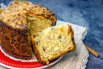 Panettone delicious christmas italian traditional cupcake closeup. Sliced cupcake with pieces of dried fruit on a dark background, copy space