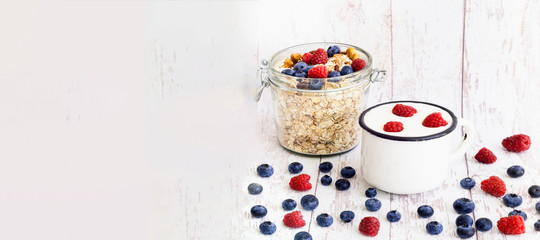 Organic Yogurt and Muesli with blueberries in glass jar on wooden background. The concept of healthy breakfast and coronavirus food