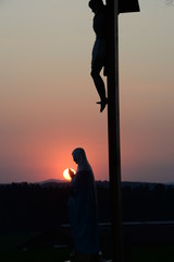 Sonnenuntergang vor Marienstatue und Kreuz