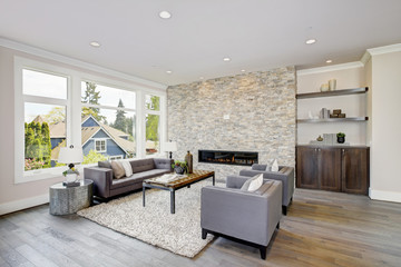 Modern great room with a floor to ceiling stone fireplace. Luxury American modern home.