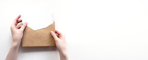 Envelope and white empty letter mock-up in female hands top view with copy space. Communication,...