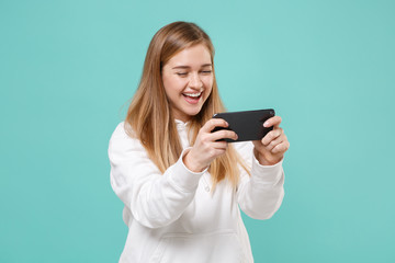 Cheerful young woman girl in casual white hoodie posing isolated on blue turquoise wall background...