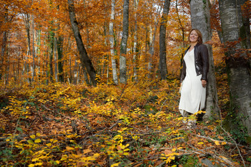 Woman in a beech forest in autumn smiling