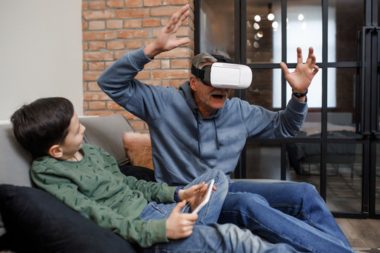 Grandfather and grandson are using vr box while relaxing at home bed
